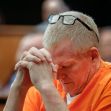 Alex Murdaugh, wearing an orange prison jumpsuit, sits with his hands clasped and head bowed during a court proceeding. Alex Murdaugh, wearing an orange prison jumpsuit, sits with his hands clasped and head bowed during a court proceeding.