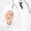 A medical professional in a white coat holding a pen, suggesting a professional context. A medical professional in a white coat holding a pen, suggesting a professional context.