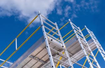 Scaffolding against a blue sky, highlighting safety concerns in construction.