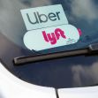 A close-up of an Uber and Lyft sticker displayed on a car windshield, highlighting the ride-share services. A close-up of an Uber and Lyft sticker displayed on a car windshield, highlighting the ride-share services.