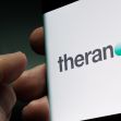 Logo of Theranos displayed on a mobile device. Logo of Theranos displayed on a mobile device.