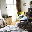 An elderly woman in a wheelchair looking out a window in a nursing home room. An elderly woman in a wheelchair looking out a window in a nursing home room.