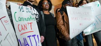 Demonstrators hold signs advocating for the legalization of marijuana and community reinvestment in New York.
