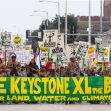 A protest march with participants holding banners and signs advocating against the Keystone XL Pipeline, emphasizing the protection of land, water, and climate. A protest march with participants holding banners and signs advocating against the Keystone XL Pipeline, emphasizing the protection of land, water, and climate.