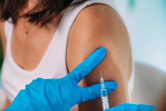 A healthcare professional administering a vaccination to a patient's arm.