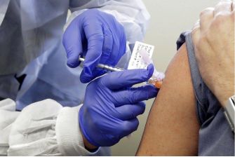 A healthcare worker administering a COVID-19 vaccine to a patient.