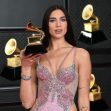 Dua Lipa posing with a Grammy Award at a red carpet event. Dua Lipa posing with a Grammy Award at a red carpet event.