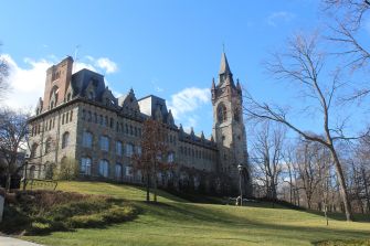 Exterior view of a historic building at Lehigh University on a clear day with blue sky and trees in the foreground.