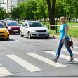 A pedestrian crossing a street while vehicles approach. A pedestrian crossing a street while vehicles approach.