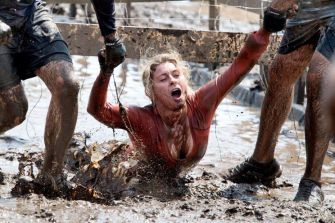 Participants struggling in muddy conditions during a Tough Mudder race.