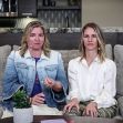 Two women sitting on a couch, discussing a topic, with a plant and papers on the table in front of them. Two women sitting on a couch, discussing a topic, with a plant and papers on the table in front of them.