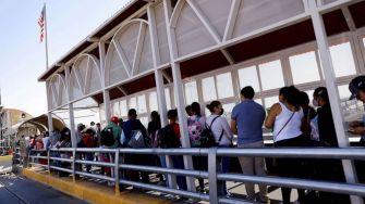 A line of people waiting at a border checkpoint in the United States.