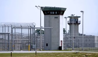 View of prison towers surrounded by fencing.