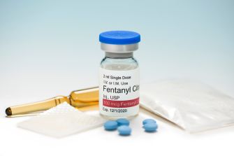 Image showing a vial of fentanyl alongside other drug-related items, highlighting the issue of fentanyl misuse and trafficking.