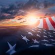 A US flag gently waving in the wind with a sunset backdrop. A US flag gently waving in the wind with a sunset backdrop.