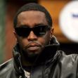 Sean Combs wearing sunglasses and a black leather jacket, seated with a serious expression. Sean Combs wearing sunglasses and a black leather jacket, seated with a serious expression.