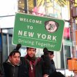 A group of people holding a "Welcome to New York" sign promoting the Green Light NY law, which allows undocumented immigrants to obtain driver's licenses. A group of people holding a "Welcome to New York" sign promoting the Green Light NY law, which allows undocumented immigrants to obtain driver's licenses.