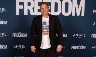 Tim Ballard standing in front of a promotional backdrop for the film "Sound of Freedom."