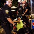 A police officer stands beside an injured hot dog vendor on the ground at a Pride event in Washington Square Park. A police officer stands beside an injured hot dog vendor on the ground at a Pride event in Washington Square Park.