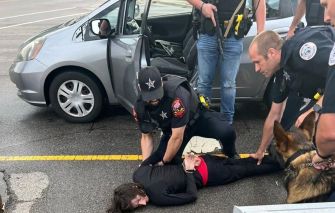 Police officers apprehending a suspect involved in the Highland Park shooting incident.