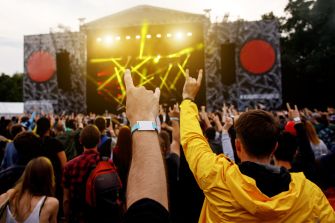 Crowd enjoying a music festival with colorful stage lights and vibrant atmosphere.