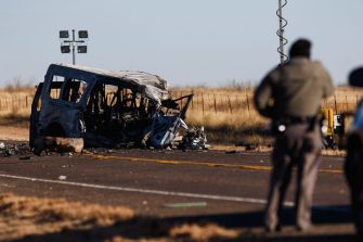 A damaged vehicle involved in a tragic crash in West Texas, with a law enforcement officer in the foreground.