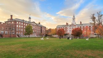 Harvard University campus with historic buildings and a grassy area during autumn.