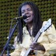 Tracy Chapman performing on stage with a guitar. Tracy Chapman performing on stage with a guitar.