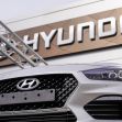 Close-up of a Hyundai vehicle in front of a Hyundai dealership sign. Close-up of a Hyundai vehicle in front of a Hyundai dealership sign.