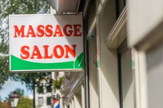Sign for a massage salon, indicating the business type and services offered.