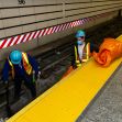 Two workers in safety gear performing maintenance on subway tracks. Two workers in safety gear performing maintenance on subway tracks.