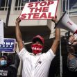 A group of people protesting with signs, including one that says "STOP THE STEAL" and another that says "COUNT LEGAL VOTES!!!" A group of people protesting with signs, including one that says "STOP THE STEAL" and another that says "COUNT LEGAL VOTES!!!"