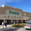 Publix store exterior with customers and parked cars. Publix store exterior with customers and parked cars.