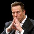 Elon Musk seated with his hands clasped in front of his face, looking serious. Elon Musk seated with his hands clasped in front of his face, looking serious.