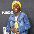 Rapper Quando Rondo smiling at a red carpet event, wearing a yellow beanie and denim jacket. Rapper Quando Rondo smiling at a red carpet event, wearing a yellow beanie and denim jacket.