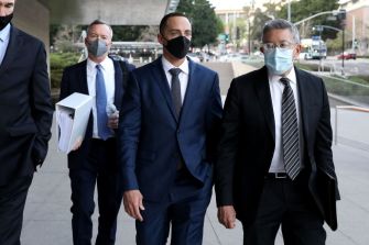 Zachary Horwitz walking with legal representatives outside a courthouse.