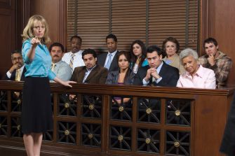 A courtroom scene showing a juror pointing while other jurors look on attentively.