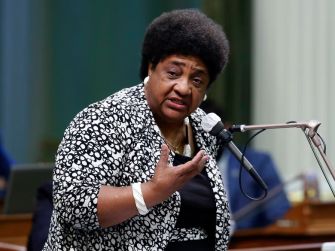 A woman speaking passionately at a podium during a legislative session.
