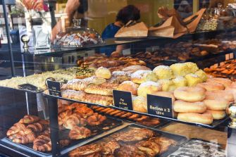 Display case filled with various baked goods, including pastries, donuts, and cookies.
