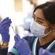 A healthcare worker prepares a COVID-19 vaccine at a vaccination site. A healthcare worker prepares a COVID-19 vaccine at a vaccination site.