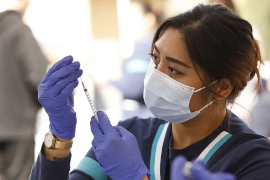 Student registered nurse Camille Endicio prepares Pfizer COVID-19 vaccination syringes at a walk-up mobile COVID-19 clinic in April in Los Angeles.(Al Seib/Los Angeles Times)