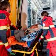 Paramedics loading a patient onto a stretcher in an ambulance during a medical emergency. Paramedics loading a patient onto a stretcher in an ambulance during a medical emergency.
