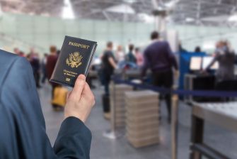 A person holding a U.S. passport in an airport security line.