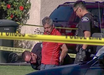 A man in handcuffs is being detained by police at the scene of an accident involving a six-year-old girl.