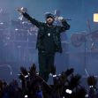 Eminem performing on stage with an enthusiastic audience in the foreground. Eminem performing on stage with an enthusiastic audience in the foreground.