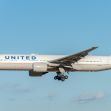 United Airlines airplane flying in a clear blue sky. United Airlines airplane flying in a clear blue sky.