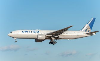 United Airlines airplane flying in a clear blue sky.