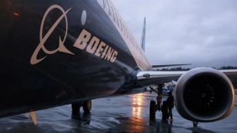 Boeing 737 Max aircraft parked at an airport with the Boeing logo visible on the side.