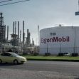 ExxonMobil facility with large storage tank and industrial structures in the background. ExxonMobil facility with large storage tank and industrial structures in the background.
