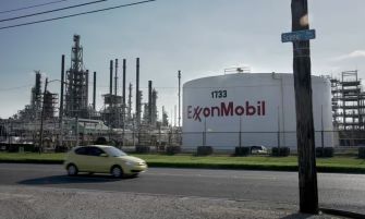 ExxonMobil facility with large storage tank and industrial structures in the background.